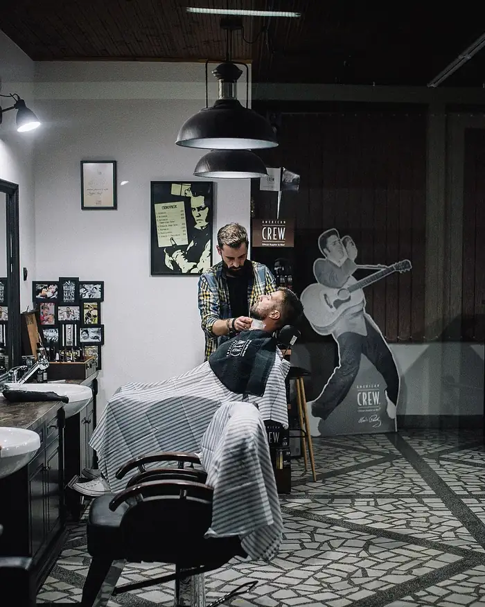 A barber giving a client a beard trim